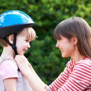 child putting on bike helmet
