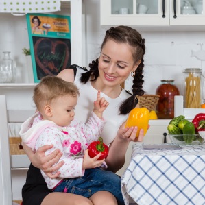 woman in kitchen with little girl and vegetables