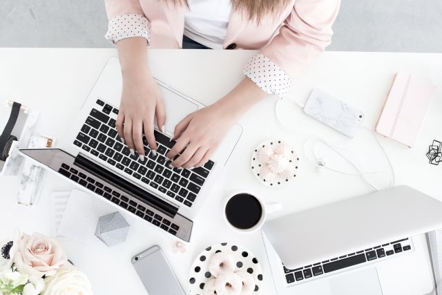 Woman in pink working on laptop