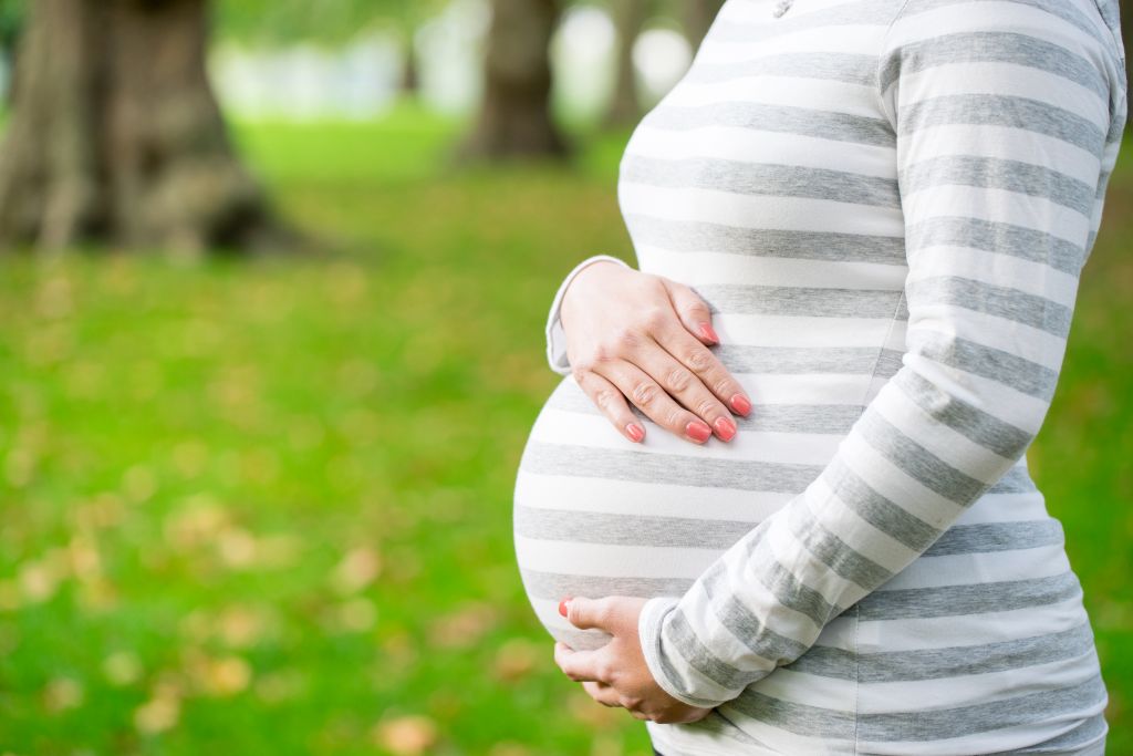 Pregnant woman with hands on bump