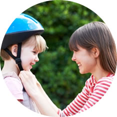 child putting on bike helmet