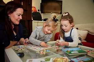 nanny doing a jigsaw with two girls